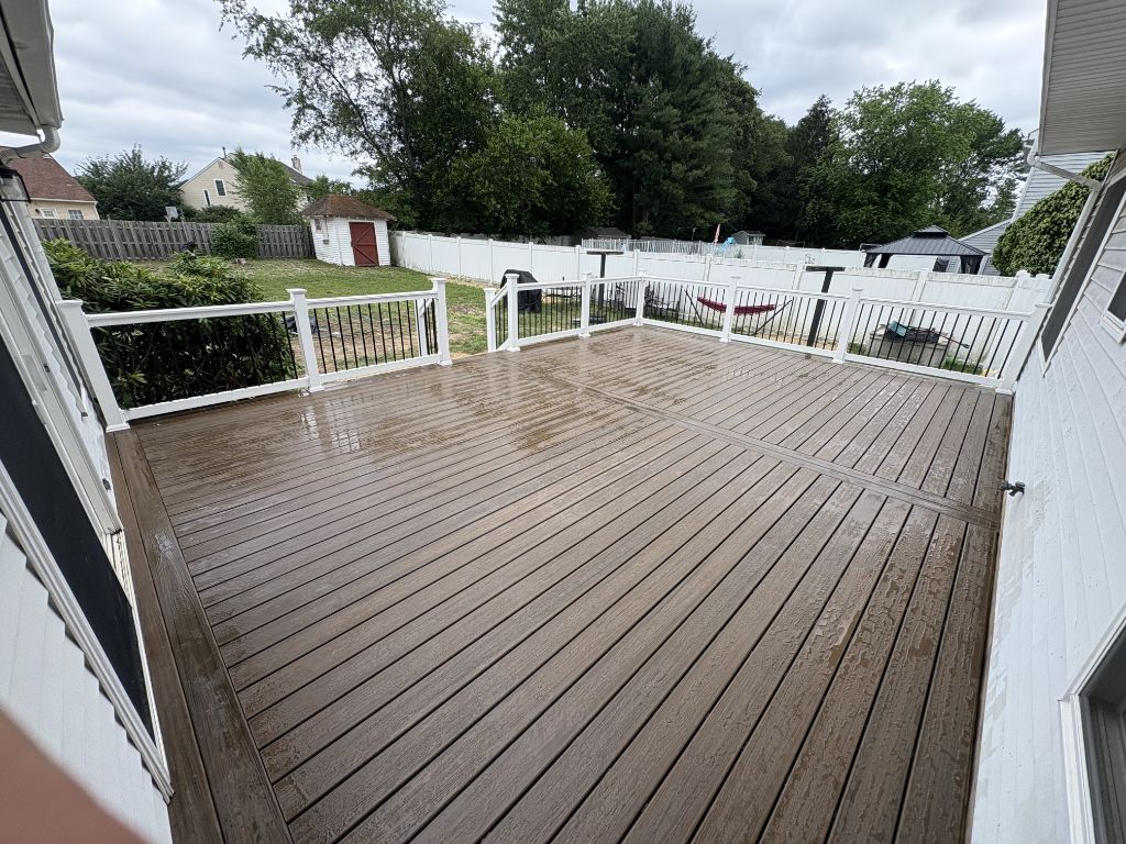 Large tan composite deck with white railing — viewed from house
