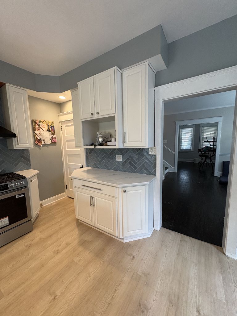 White kitchen remodel with custom cabinetry and herringbone tile