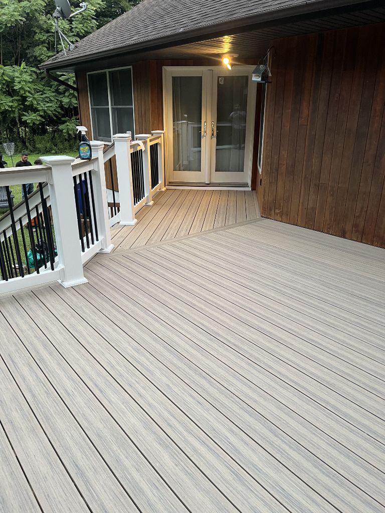 Tan composite deck with white railing photographed at dusk