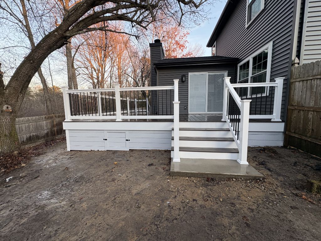 Dark composite deck with under-deck storage door and stairs