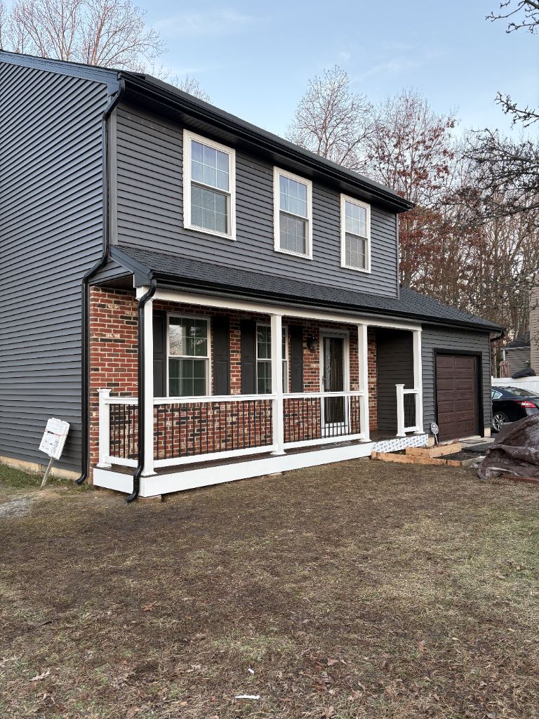 Dark charcoal siding on brick-front colonial home