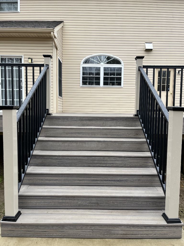 Gray composite deck with center stairs and black aluminum railing