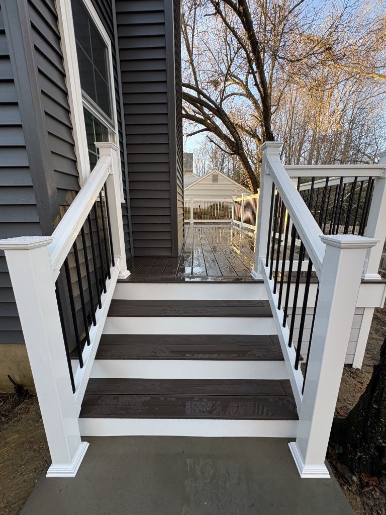 White post and black aluminum baluster railing with dark composite stairs — AMG Contractors South Jersey