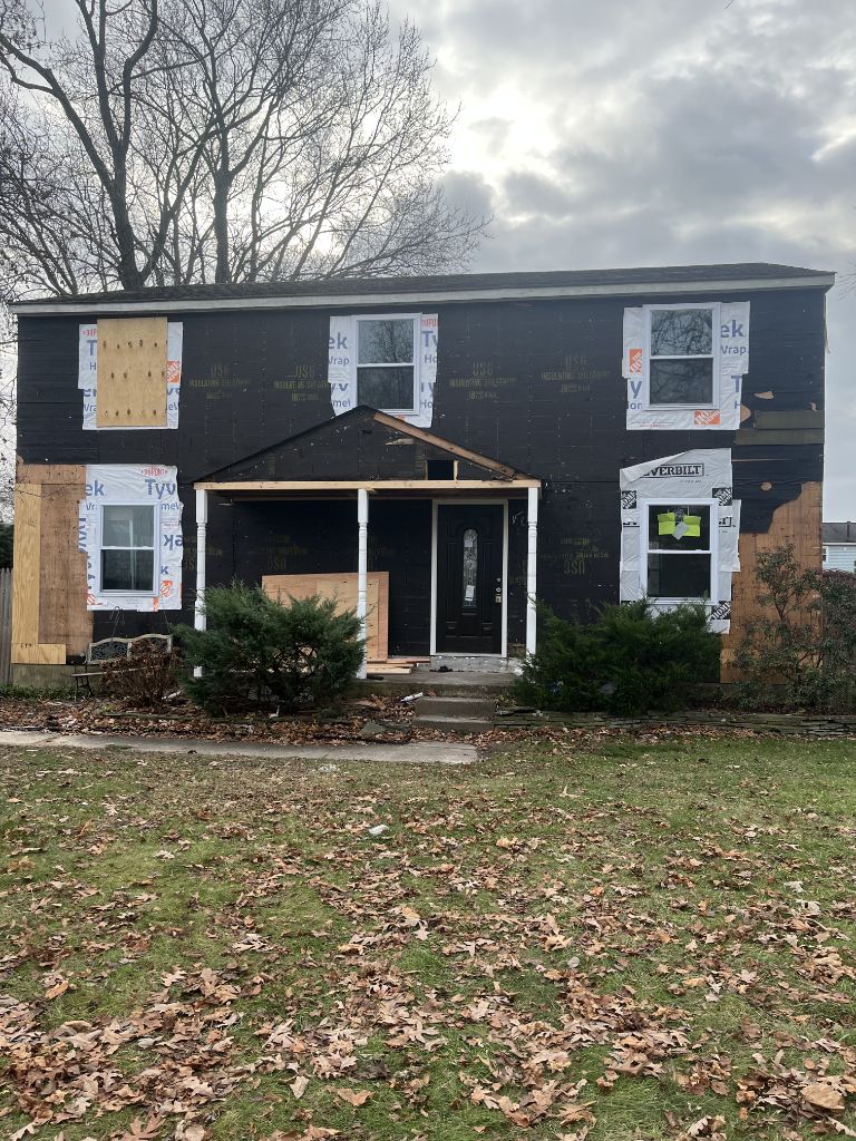 Tyvek wrap and siding installation in progress on two-story home